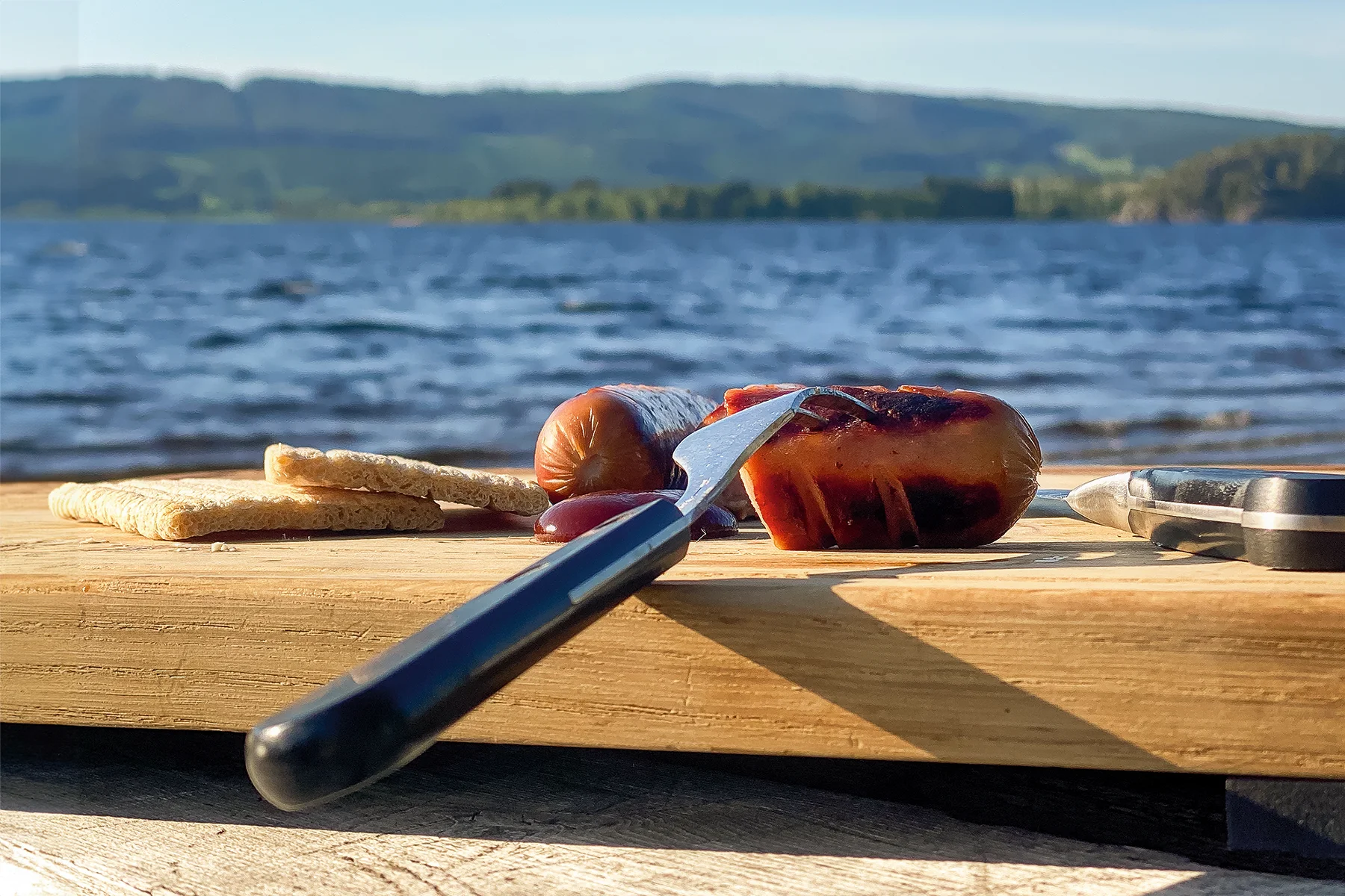 WOLFBOARD.one (Holz Schneidebrett) im Outdoor Einsatz am See mit Messer und Grillgut