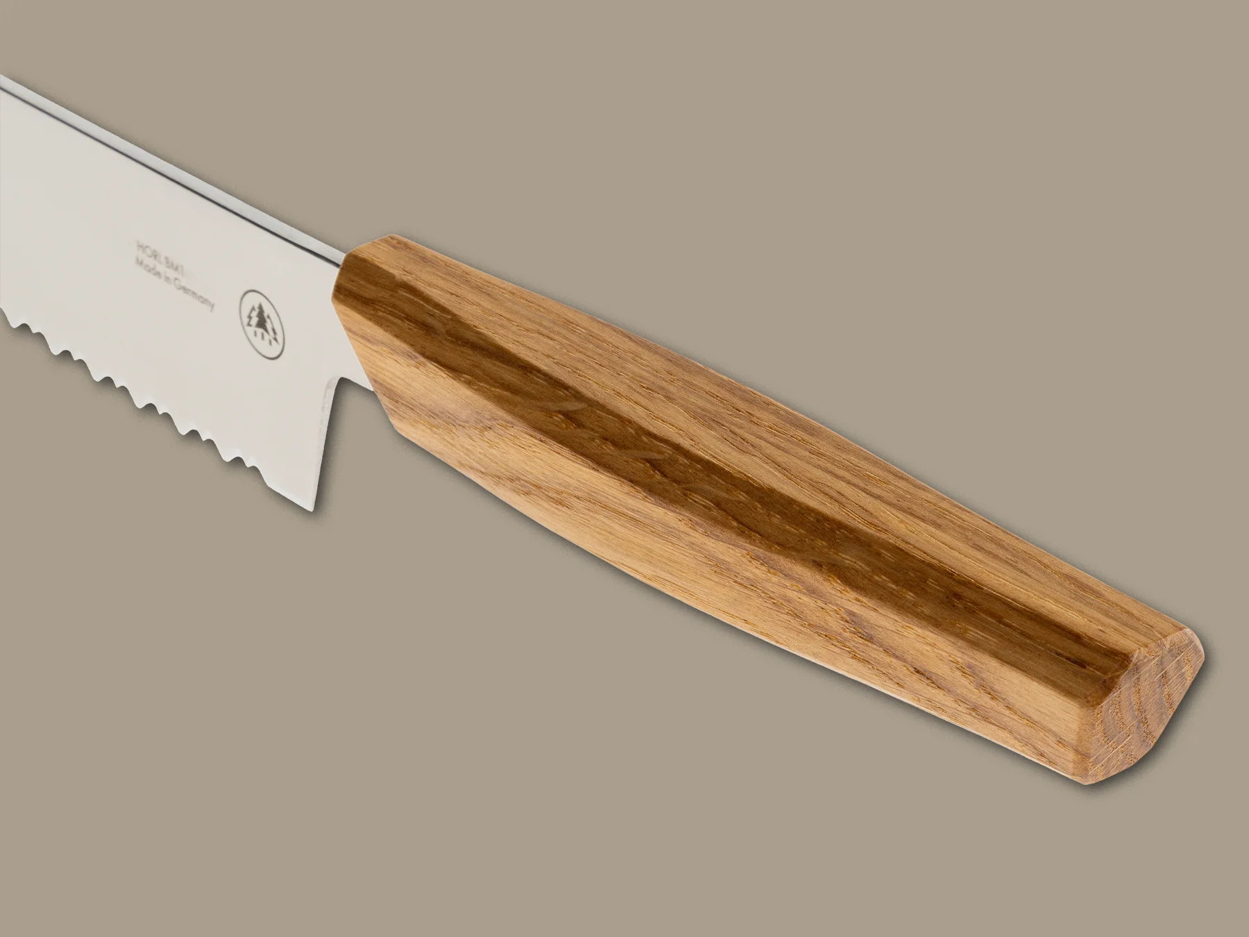 HORL® Brotmesser Eichenholzgriff im Detail mit markanter Holzmaserung auf beige-grauem Hintergrund